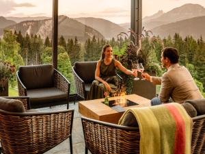 a man and woman sitting around a table with wine glasses at Holiday Home Wilderer by Interhome in Pichl