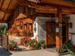 a wooden building with flowers in front of it at Holiday Home Wilderer by Interhome in Pichl