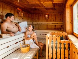 un hombre y una mujer sentados en una sauna en Holiday Home Försterin by Interhome en Pichl