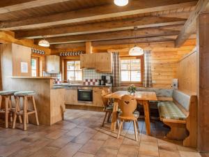 cocina con paredes de madera, mesa y sillas en Holiday Home Försterin by Interhome en Pichl