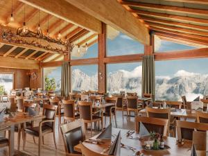 un restaurante con mesas y sillas y montañas de fondo en Holiday Home Försterin by Interhome en Pichl