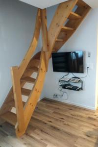 una escalera de caracol de madera en una habitación con TV en Apartment Haus Sunneschy Whg- 301 by Interhome en Parpan