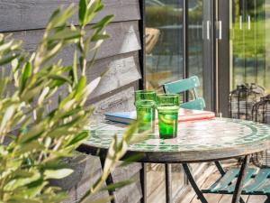 2 verres verts assis sur une table sur une terrasse dans l'établissement Holiday Home Tessa - 1-6km from the sea in Sealand by Interhome, à Græsted