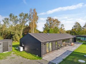 une maison modulaire noire avec une terrasse dans l'établissement Holiday Home Tessa - 1-6km from the sea in Sealand by Interhome, à Græsted