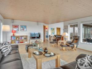 a living room with a couch and a table at Holiday Home Sahid - 20m from the sea by Interhome in Klint