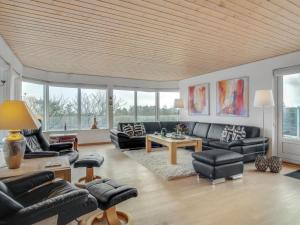 a living room with black leather furniture and windows at Holiday Home Sahid - 20m from the sea by Interhome in Klint +37 photos