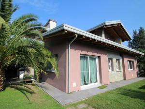 uma casa cor-de-rosa com uma palmeira à frente. em Villa Fenix by Interhome em Gravellona Toce