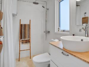 biała łazienka z umywalką i toaletą w obiekcie Holiday Home Elma - 350m from the sea in SE Jutland by Interhome w mieście Juelsminde
