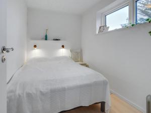 - une chambre blanche avec un lit et une fenêtre dans l'établissement Holiday Home Elma - 350m from the sea in SE Jutland by Interhome, à Juelsminde