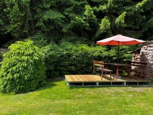 a picnic table with an umbrella and a chair on a deck at Holiday Home Hůrka by Interhome in Horní Planá +40 photos