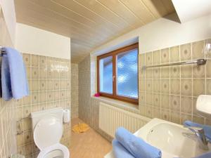 a bathroom with a toilet and a sink and a window at Apartment IN2- 2 Zimmer max- 3 Personen by Interhome in Saalbach Hinterglemm