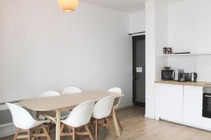 une salle à manger avec une table et des chaises blanches dans l'établissement Spacious appt close to Place Monge, à Paris