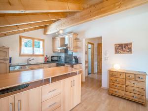 eine Küche mit Holzschränken und Holzböden in der Unterkunft Apartment Tga Stgirat Dachgeschoss by Interhome in Malmigiuer