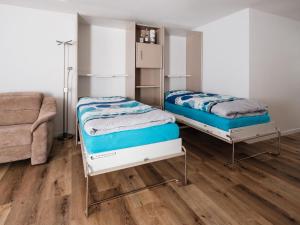 a bedroom with two beds and a couch at Apartment Haus Sunneschy Whg- 202 by Interhome in Parpan