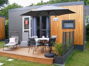 a deck with a table and chairs and an umbrella at Holiday Home Alex by Interhome in Wemding