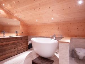 een badkamer met een groot bad en een toilet bij Chalet Chalet Le Haut Pré by Interhome in Villars-sur-Ollon