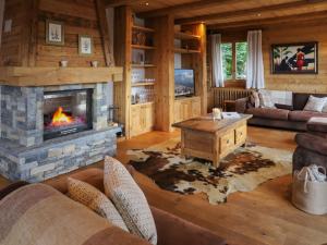 a living room with a fireplace in a log cabin at Chalet Chalet Picoulet by Interhome in Villars-sur-Ollon