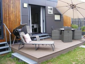 a wooden deck with a chair and an umbrella at Holiday Home Ulrike by Interhome in Wemding