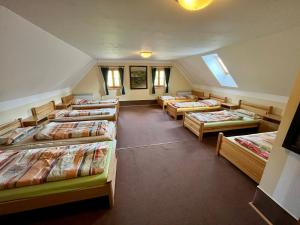 szereg łóżek w pokoju z oknami w obiekcie Holiday Home Mazurova chalupa by Interhome w mieście Býšť