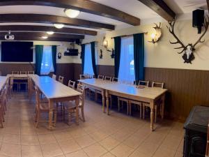 jadalnia ze stołami, krzesłami i niebieskimi zasłonami w obiekcie Holiday Home Mazurova chalupa by Interhome w mieście Býšť