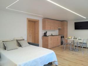 a bedroom with a white bed and a kitchen at Apartment Etoile du Matin rez by Interhome in Champex