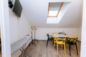 a dining room with yellow chairs and a table at Smart Apart in Vinnytsya