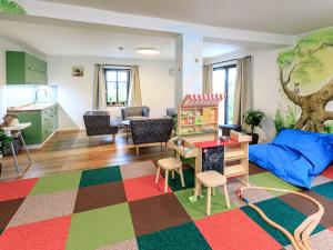 ein Wohnzimmer mit einem Kinderspielzimmer mit einem Spielzeughaus in der Unterkunft Apartment Arnoltice 5 by Interhome in Arnoltice u Decina