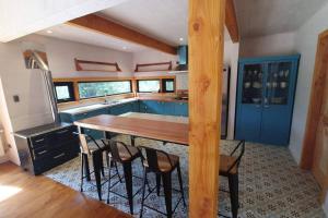 cocina con mesa de madera y algunas sillas en Espectacular y Amplia Casa en Reserva Huilo Huilo en 