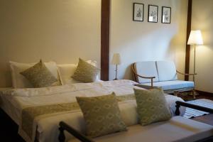 a hotel room with a bed and a chair at Maison Barn Laos in Luang Prabang