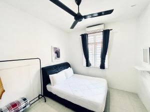 een slaapkamer met een bed en een plafondventilator bij KD Homestay Bukit Keluang Besut in Kampung Raja