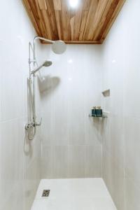 a bathroom with a shower with white tiles at Maison Barn Laos in Luang Prabang