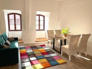 een woonkamer met een tafel en een kleurrijk tapijt bij Apartment Salzmännchen by Interhome in Zittau