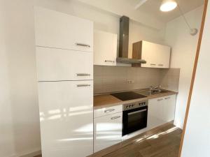 een keuken met witte kasten en een wastafel bij Apartment Salzmännchen by Interhome in Zittau