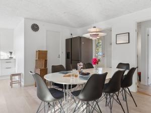cocina y comedor con mesa blanca y sillas en Holiday Home Asmine - 30m from the sea in Funen by Interhome, en Millinge