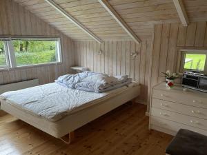 1 dormitorio con 1 cama en una habitación con paredes de madera en Holiday Home Esther - 500m from the sea in SE Jutland by Interhome en Egernsund