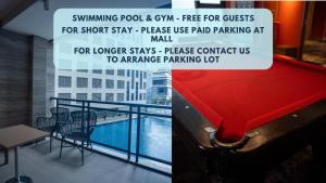 Junto a un balcón con piscina hay un cartel en Studio with Netflix, 55in TV, 200Mbs net, in heart of Makati en Manila