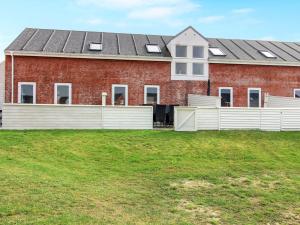 a red brick house with a white fence in front of it at Apartment Ilka - all inclusive - 2-3km from the sea by Interhome in Sønderby