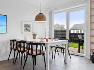 uma sala de jantar com uma mesa branca e cadeiras em Apartment Helemine - 400m from the sea in NW Jutland by Interhome em Fjerritslev