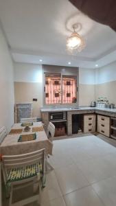 cocina grande con mesa y ventana en Tambarkiyt House Studio Appartement - Aourir Agadir en Agadir