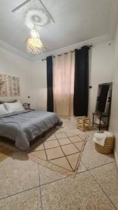 1 dormitorio con cama y lámpara de araña en Tambarkiyt House Studio Appartement - Aourir Agadir en Agadir