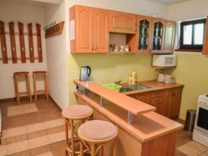 a kitchen with a counter and some stools in it at Chalet Merlin by Interhome in Janske Lazne