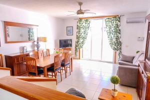 un soggiorno con tavolo, sedie e divano di Parque Santiago II Villa 2 Tenerife Rental & Sales a Playa de las Americas