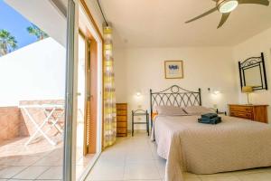 una camera da letto con un letto e un balcone di Parque Santiago II Villa 2 Tenerife Rental & Sales a Playa de las Americas Altre 70 foto