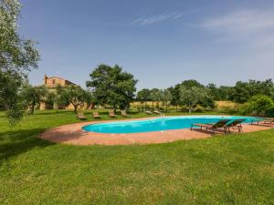 a pool in a park with picnic tables and benches at Holiday Home Il Piccione by Interhome in Sorano