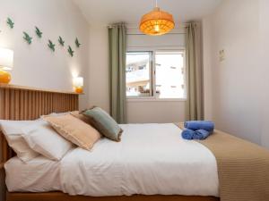 ein Schlafzimmer mit einem großen weißen Bett mit Kissen in der Unterkunft Apartment Melucia by Interhome in Lloret de Mar