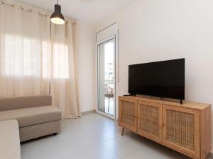 ein Wohnzimmer mit einem Flachbild-TV auf einem hölzernen Entertainment-Center in der Unterkunft Apartment Melucia by Interhome in Lloret de Mar