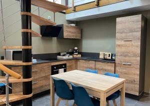 cocina con mesa de madera y sillas azules en "City House" - Maison de ville - centre ville - T3 - BY PRIMO C0NCIERGERIE, en Mâcon
