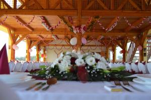 a table with a bunch of flowers on it at Joó-tó Rönk-vendégház in Marcalgergelyi