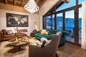 a living room with a green couch and chairs at Chalet Carte Blanche Golden Jubilée in Val Thorens