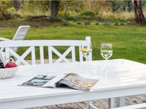 a white table with two glasses of wine and a magazine at Holiday Home Rami - 2km from the sea in Sealand by Interhome in Tisvildeleje